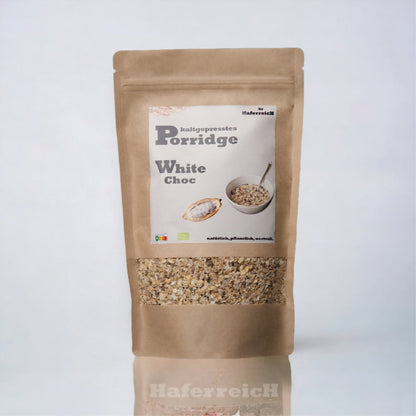 Verpackung von kaltgepresstem Porridge in der Sorte White Choc von der Marke Haferreich. Hergestellt aus frisch geflockten Haferflocken mit Rohkakaobutter und Datteln. 